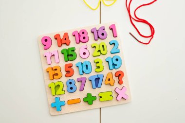 Çocuk oyun yoluyla numaraları öğreniyor. Tahta sayılar ve ayakkabı bağcıklarıyla duyusal aktivite. Evde eğitim, okul öncesi eğitim, Montessori metodolojisi. sayılar dizisi, aritmetik problemler.