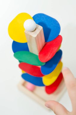 Tahta mermer yarış kulesi. Çocuklar oyun oynamak için oyun oynarlar. Çocuk topu başlangıç pozisyonuna getiriyor. Evdeki etkinlikler. Tablo ve zemin oyunu.