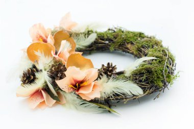 Beyaz bir masa üzerinde yosun ve süslemeli el yapımı Paskalya çelengi..