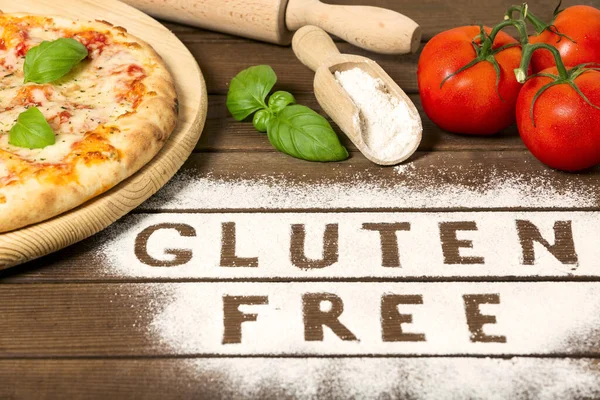 A gluten free pizza on a rustic wood background, with word \