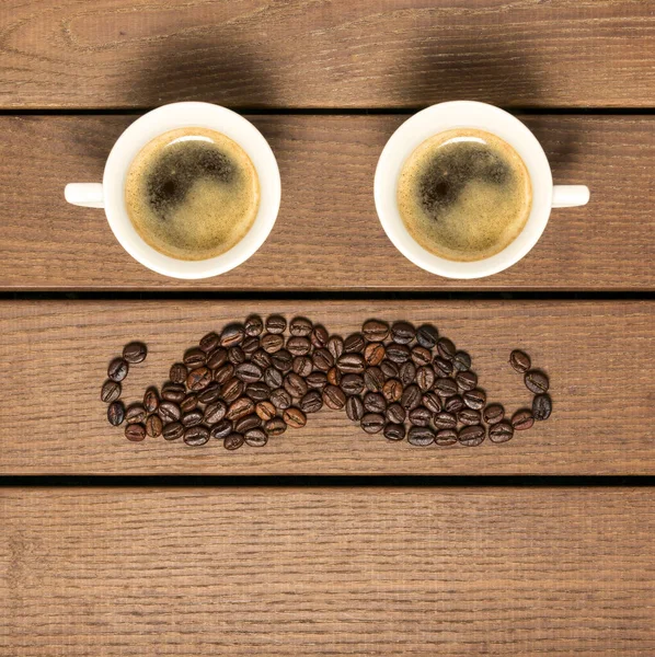 Dois Grãos Café Café Forma Bigode Contra Fundo Madeira — Fotografia de Stock