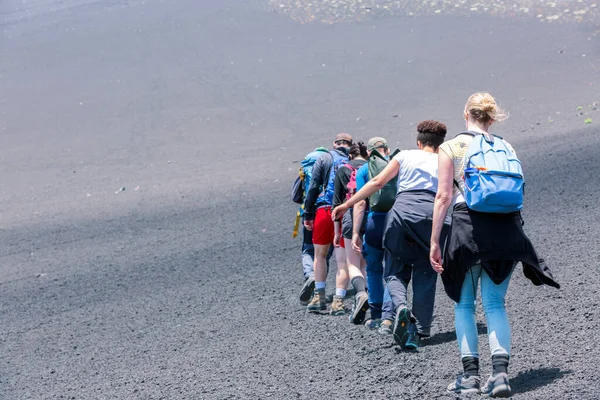 People trekking at Mount Etna volcano, Sicily, Italy.
