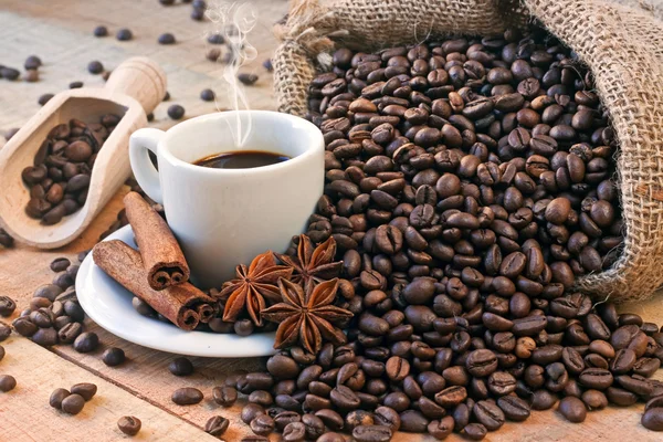 Kaffekopp och spannmål på träbord — Stockfoto