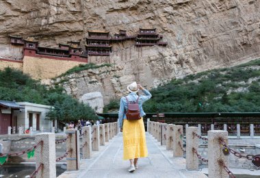 Çin 'in Shanxi Eyaleti' nde Datong yakınlarında Asılı Tapınak veya Asılı Manastır 'a bakan genç bir turist.  