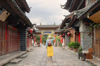 Genç bayan turist, Çin 'in Yunnan eyaletindeki ünlü turizm beldesi Lijiang Antik Kasabasını ziyaret ediyor.