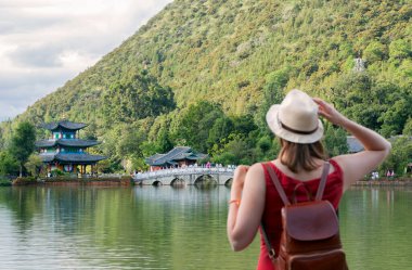 Siyah Ejder Havuzu 'nda seyahat eden genç bir gezgin ve Lijiang Eski Kasabası yakınlarındaki turistler için popüler bir yer. Lijiang, Yunnan, Çin