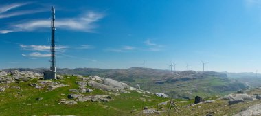 Avrupa 'da (Norveç) kırsal dağların üzerinden cep telefonu baz istasyonunun yanında gezen yürüyüşçü, arka planda fiyortlarla