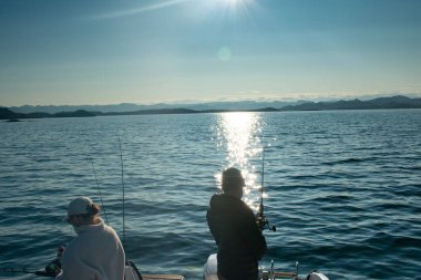 Stavanger Norveç yakınlarındaki bir teknede olta atan çift (jig fish fish)