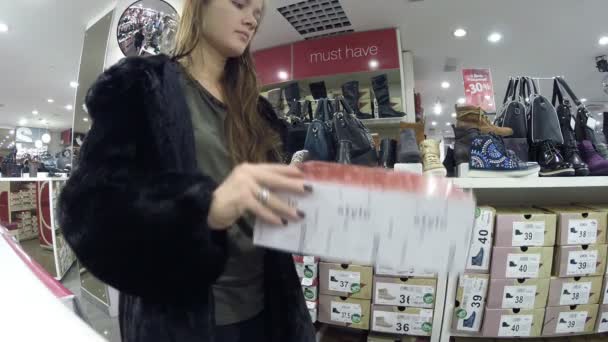 Η κοπέλα στο κατάστημα επιλέγει παπούτσια Centro σε Ufa, Ρωσική Ομοσπονδία — Αρχείο Βίντεο