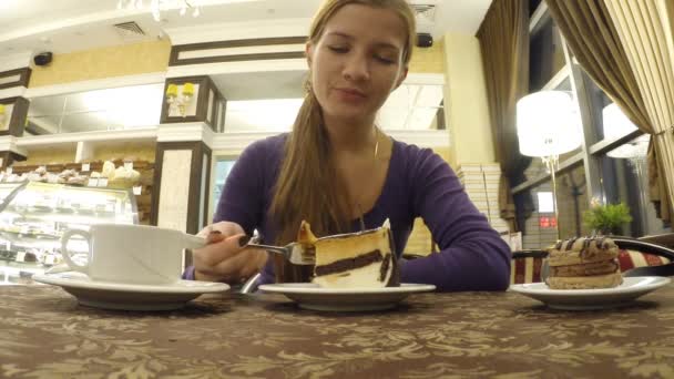 La jeune fille boit du café en parlant au café — Video