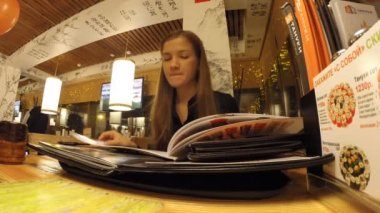 Kız menü Japon lokantasında okuyor