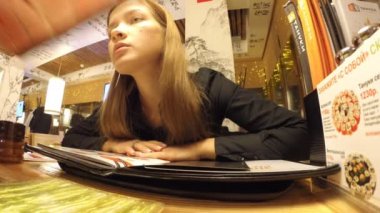 Kız menü Japon lokantasında okuyor