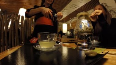 Kız bir Japon restoran Tanuki çay içecekler