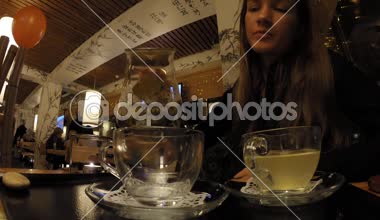 Kız bir Japon restoran Tanuki çay içecekler