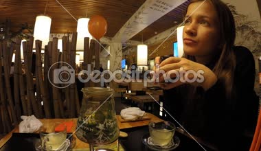 Kız bir Japon restoran Tanuki çay içecekler