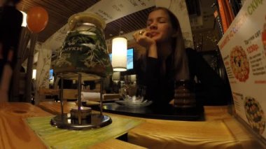 Kız bir Japon restoran Tanuki çay içecekler