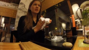 Kız bir Japon restoran Tanuki çay içecekler