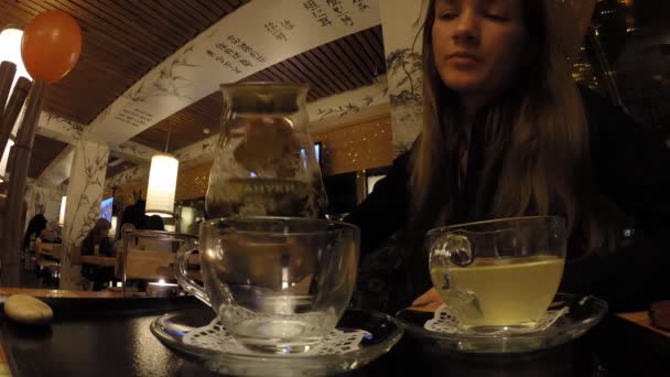女の子は、日本レストランたぬきで茶を飲む — ストック動画