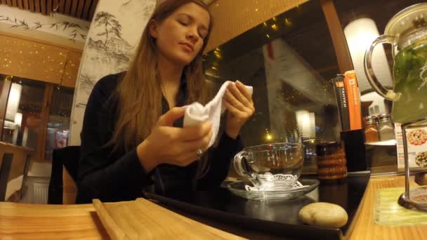 Дівчина п'є чай у японський ресторан Танукі — стокове відео