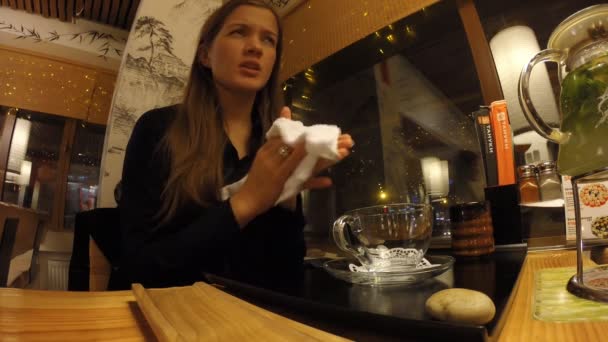 Das Mädchen trinkt Tee in einem japanischen Restaurant tanuki — Stockvideo