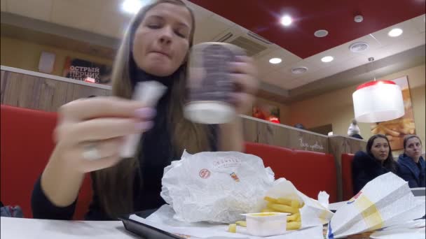 The girl eats at restaurant Burger King — Stock Video