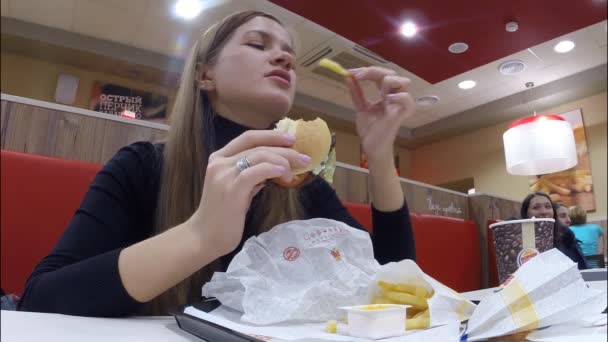 The girl eats at restaurant Burger King — Stock Video