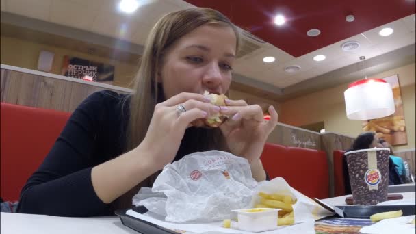 A menina come no restaurante Burger King — Vídeo de Stock