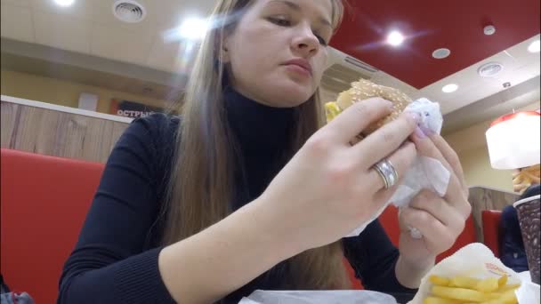 The girl eats at restaurant Burger King — Stock Video