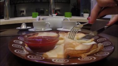 Kız bir café restoranında Frambuaz reçeli ile krep yiyor