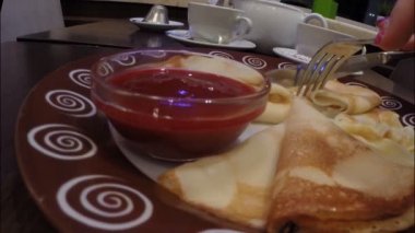 Kız bir café restoranında Frambuaz reçeli ile krep yiyor
