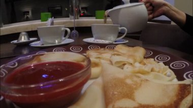 Kız bir café restoranında Frambuaz reçeli ile krep yiyor