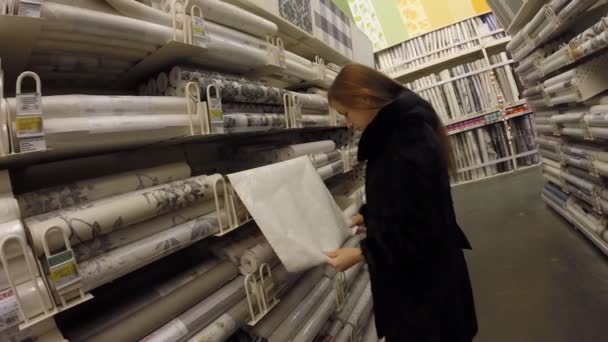 Chica elige la tienda de papel pintado Leroy Merlin — Vídeo de stock