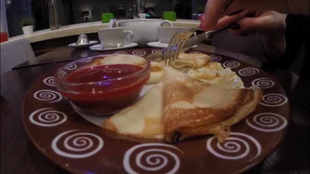 Tjej äter pannkakor med hallonsylt i café restaurang — Stockvideo