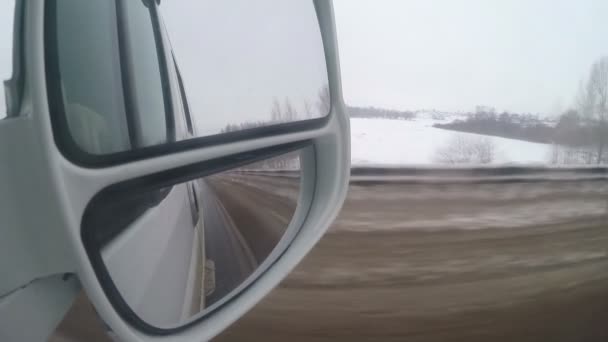 Kış road, dikiz ayna görünümünde. Beyaz araba, karlı iz — Stok video