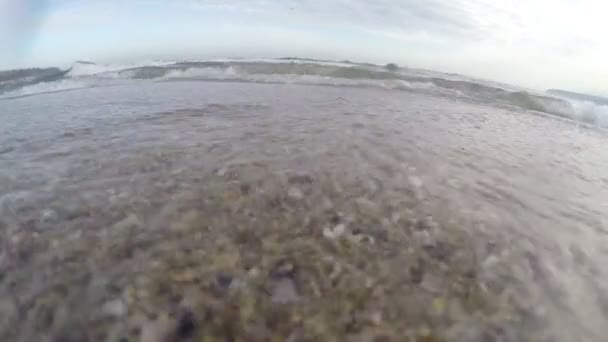 Ondas do mar, a câmara na areia, a água a entrar na lente . — Vídeo de Stock