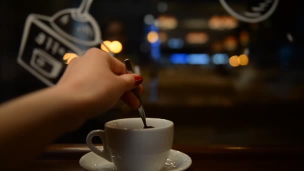 Young girl drinking tea in a cafe in the evening — Stock Video