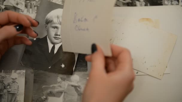 Una mujer viendo un viejo álbum de fotos con niños (infantes) fotografías de la URSS — Vídeos de Stock