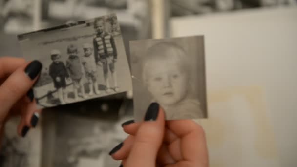 Eine Frau beim Betrachten eines alten Fotoalbums mit Kinder- (Säuglings-) Fotografien des — Stockvideo