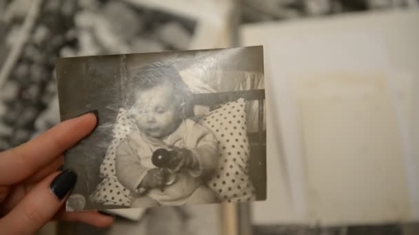 Eine Frau beim Betrachten eines alten Fotoalbums mit Kinder- (Säuglings-) Fotografien des — Stockvideo