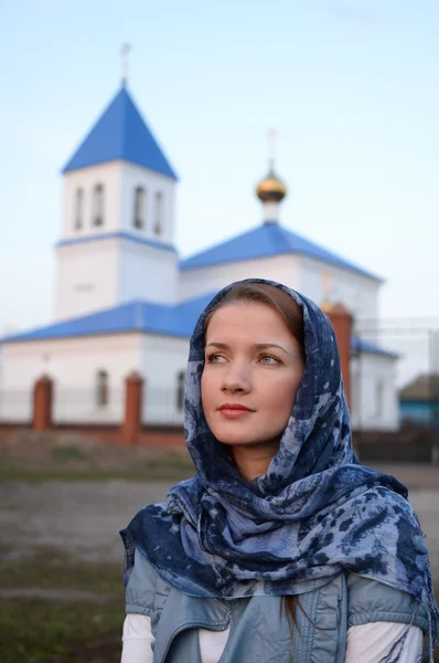 Девушка славянской русской внешности в шарфе на фоне церкви — стоковое фото
