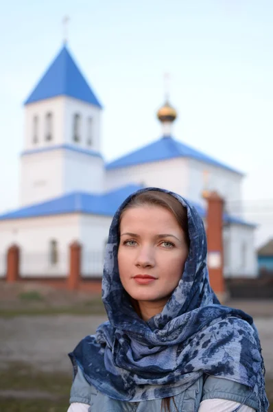 Dziewczyna słowiańskich rosyjski pojawienia się w szalik na tle Kościoła — Zdjęcie stockowe