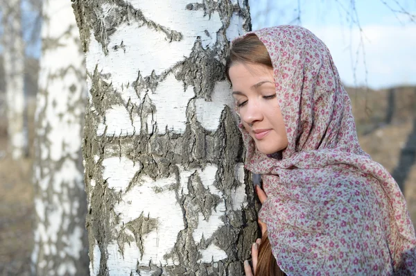 Menina russa em um lenço em uma floresta de vidoeiro perto — Fotografia de Stock