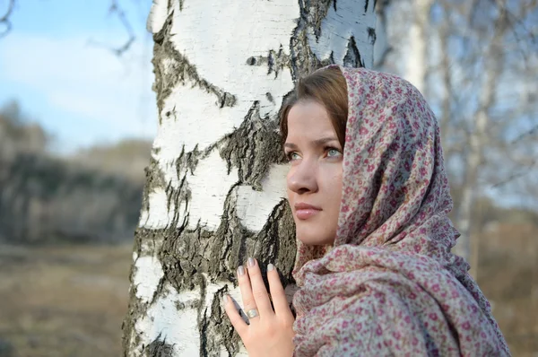 Ragazza russa in una sciarpa in una foresta di betulle da vicino — Foto Stock