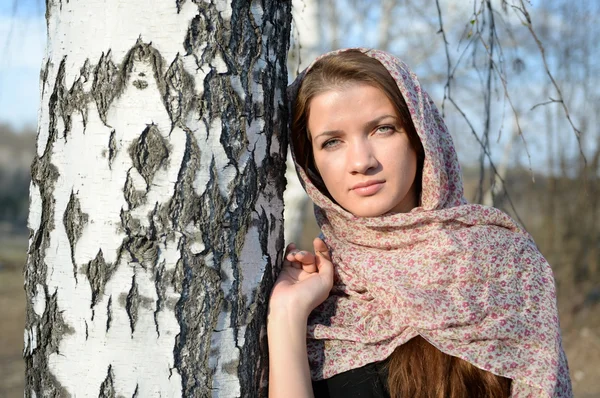 Menina russa em um lenço em uma floresta de vidoeiro perto — Fotografia de Stock