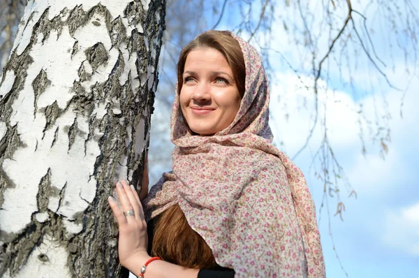 Chica rusa en una bufanda en un bosque de abedul de cerca — Foto de Stock