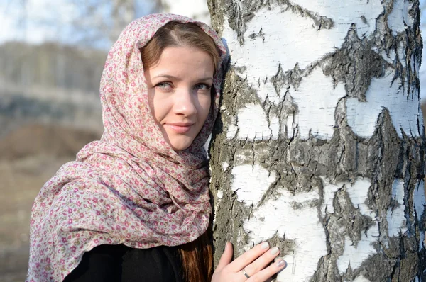 Russian girl in a scarf in a birch forest close up Stock Photo