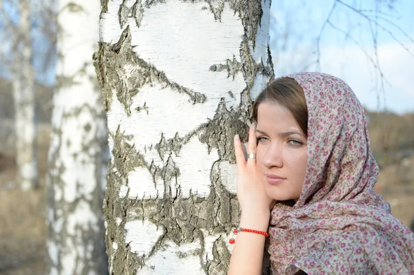 Russian girl in a scarf in a birch forest close up Royalty Free Stock Images