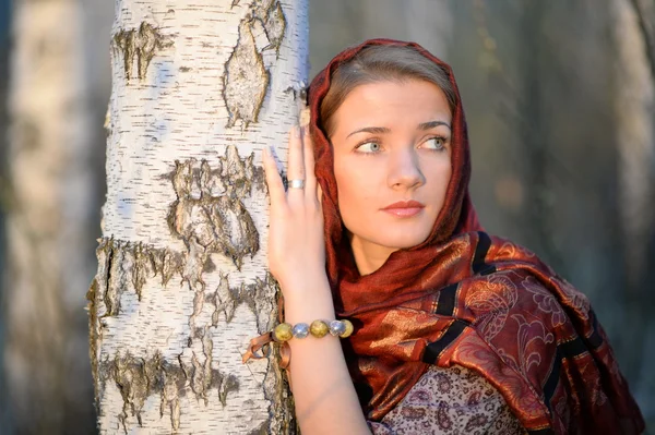 Menina russa em um lenço em uma floresta de vidoeiro, close-up — Fotografia de Stock