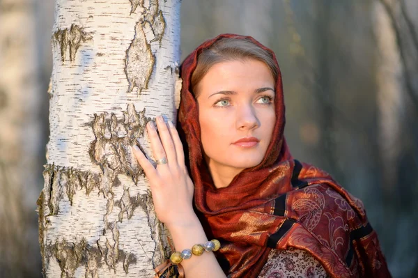 Menina russa em um lenço em uma floresta de vidoeiro, close-up — Fotografia de Stock