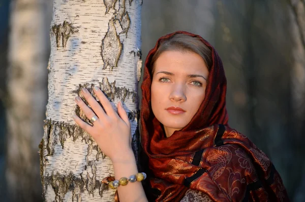 Menina russa em um lenço em uma floresta de vidoeiro, close-up — Fotografia de Stock